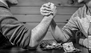 Arm-wrestling over money.