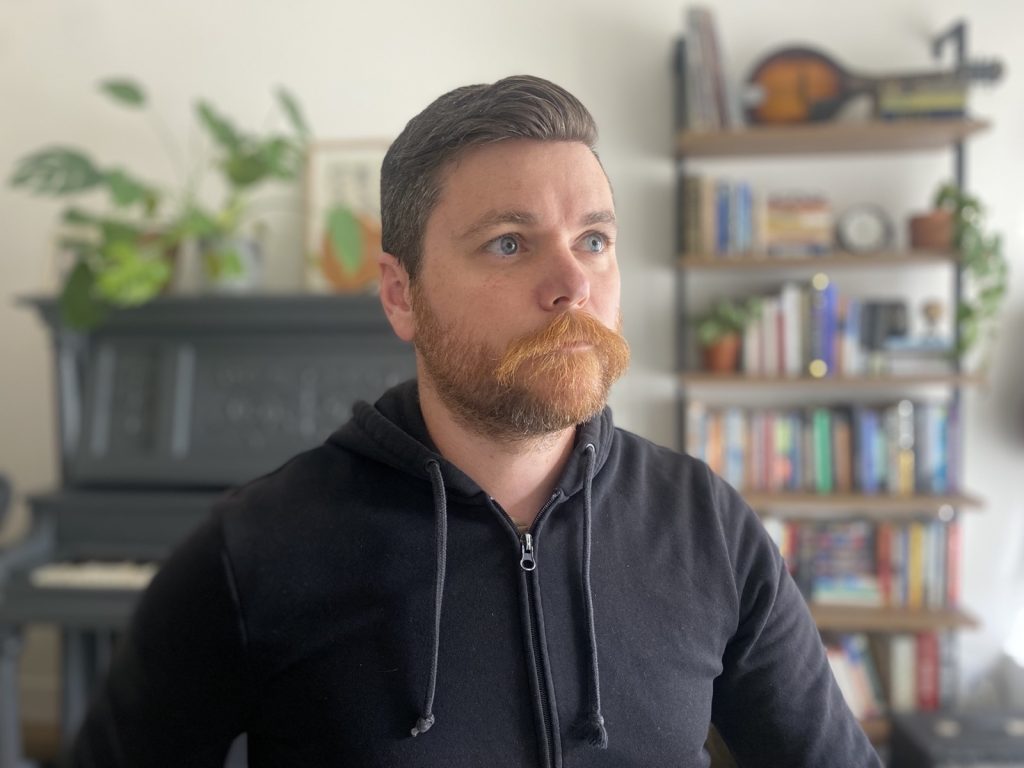 Headshot of Brian Coords in his office, looking upward with a neutral expression