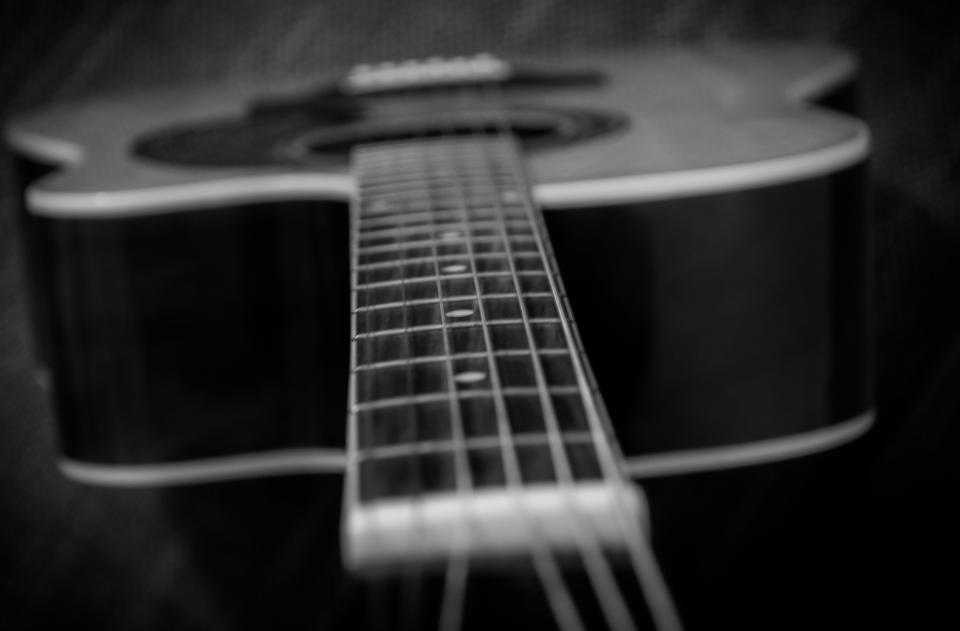 An acoustic guitar with the neck angled toward the camera